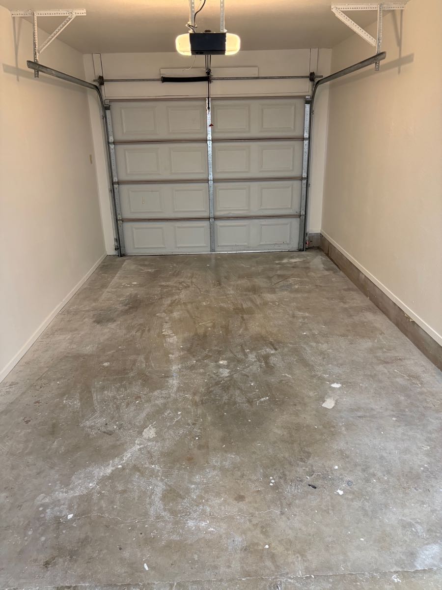The same garage swept down to bare concrete with every piece of renovation debris hauled out